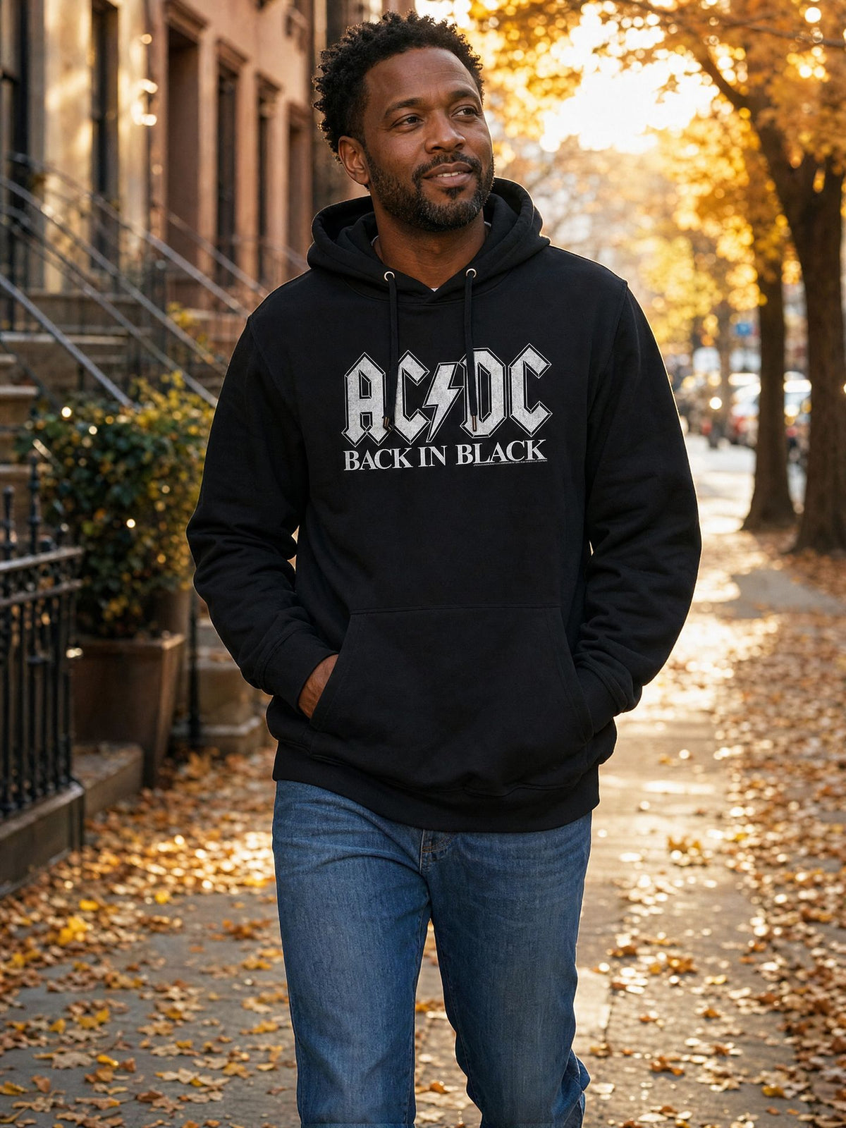 Man wearing the officially licensed AC/DC Back In Black hooded sweatshirt on an autumn city street. AI-generated lifestyle image.